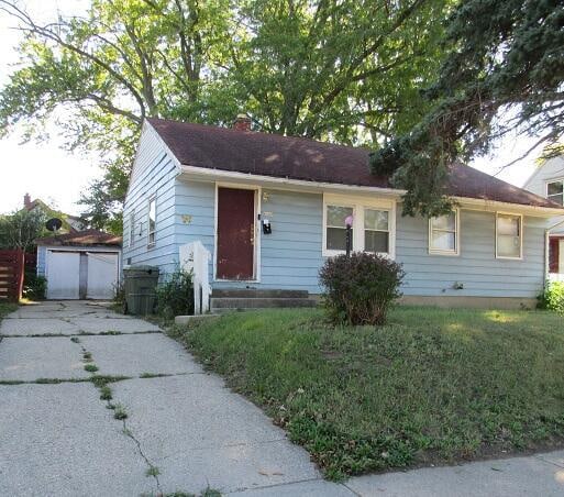 view of front of home featuring a front yard and an outdoor structure