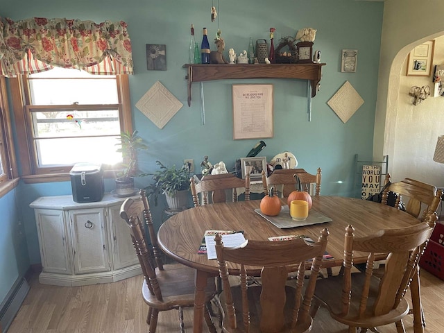 dining area with light hardwood / wood-style flooring and a baseboard radiator