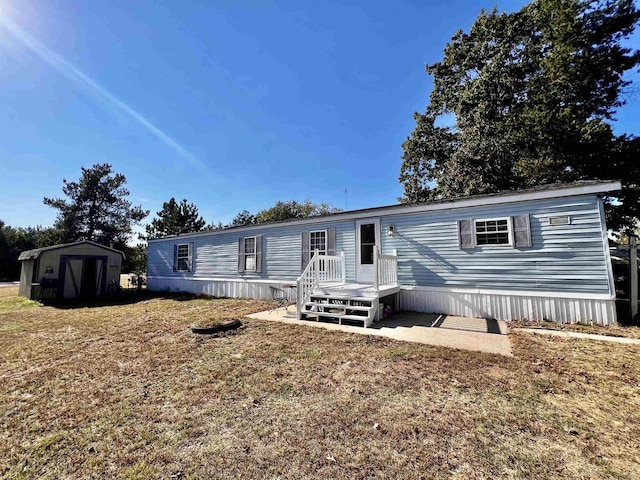 manufactured / mobile home featuring a front yard and a storage unit