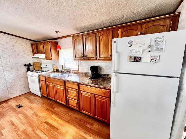 kitchen featuring white appliances, light wood-type flooring, crown molding, decorative light fixtures, and sink