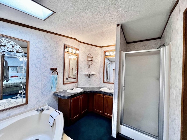 bathroom featuring shower with separate bathtub, a textured ceiling, a skylight, ornamental molding, and vanity