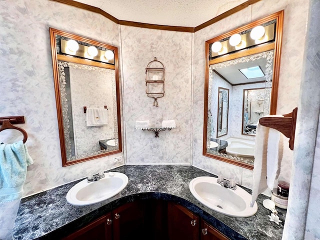 bathroom with a textured ceiling, crown molding, vanity, and a skylight