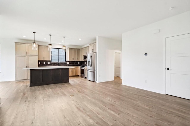 kitchen featuring a center island, light hardwood / wood-style floors, hanging light fixtures, and appliances with stainless steel finishes