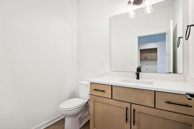 bathroom featuring toilet, vanity, and hardwood / wood-style flooring