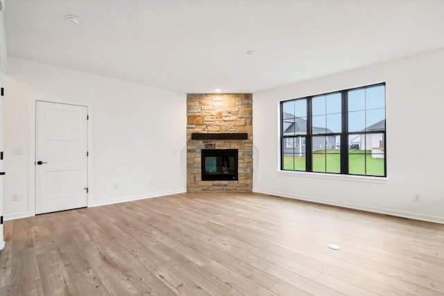 unfurnished living room featuring a fireplace and light hardwood / wood-style flooring