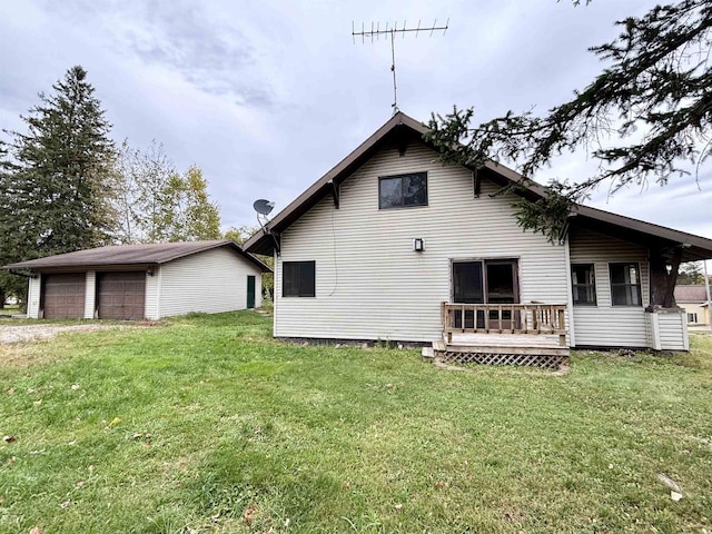 rear view of property with an outdoor structure, a yard, and a garage