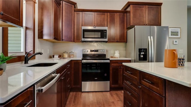 kitchen featuring stainless steel appliances, light hardwood / wood-style flooring, and sink