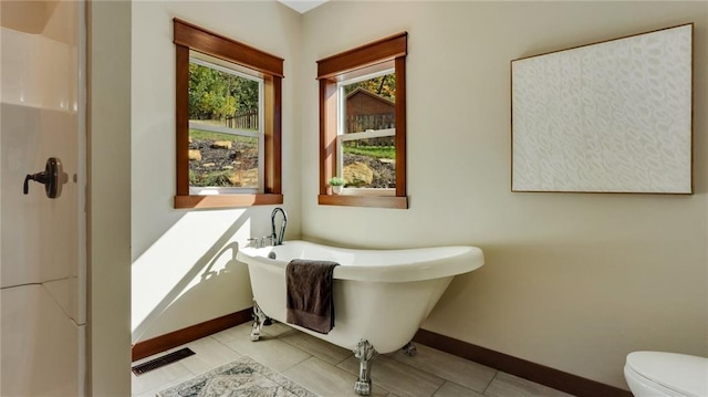 bathroom with tile patterned flooring, toilet, and a washtub