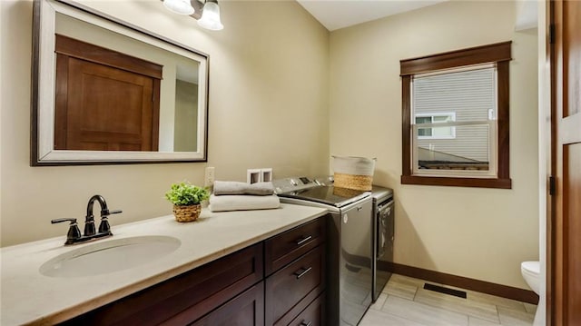 bathroom with independent washer and dryer, vanity, and toilet