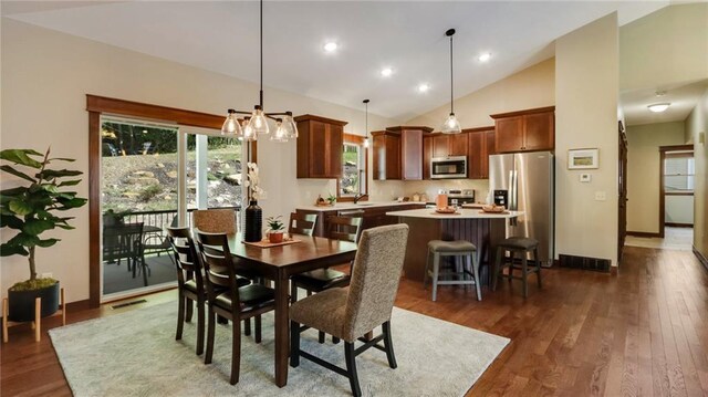 dining area featuring dark hardwood / wood-style floors, sink, and high vaulted ceiling