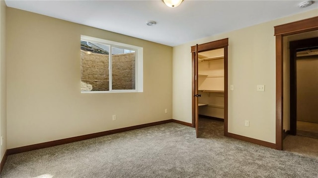 unfurnished bedroom featuring light carpet, a closet, and a walk in closet