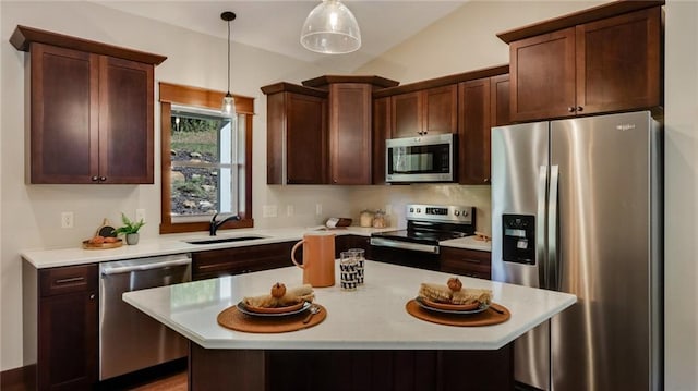 kitchen featuring decorative light fixtures, sink, stainless steel appliances, lofted ceiling, and a center island