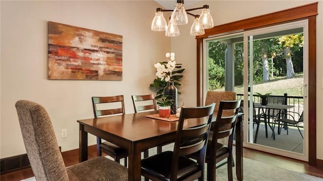 dining area featuring a notable chandelier and wood-type flooring