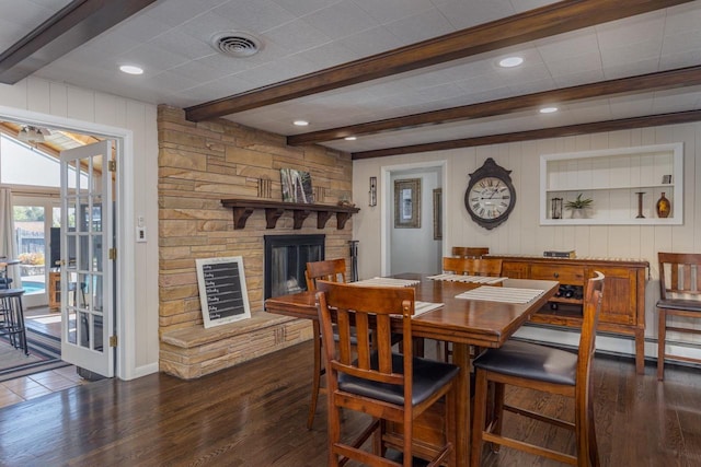 dining space with a fireplace, beam ceiling, and dark wood-type flooring