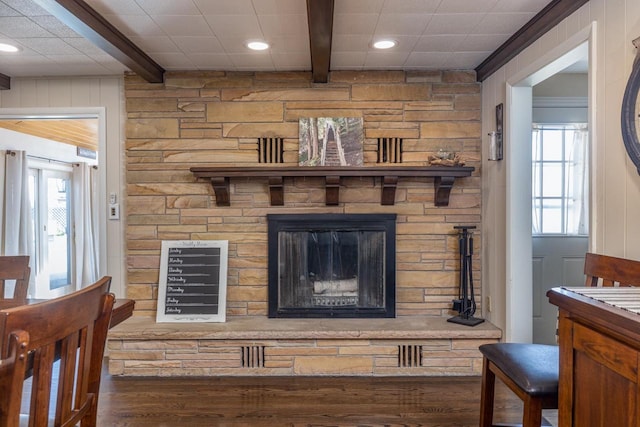 room details featuring a fireplace, beamed ceiling, wood-type flooring, crown molding, and beverage cooler