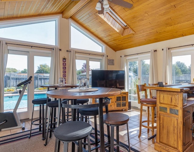 tiled dining area with wood ceiling, lofted ceiling with beams, and a healthy amount of sunlight