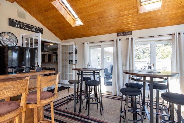 kitchen featuring wood ceiling, vaulted ceiling with skylight, and french doors