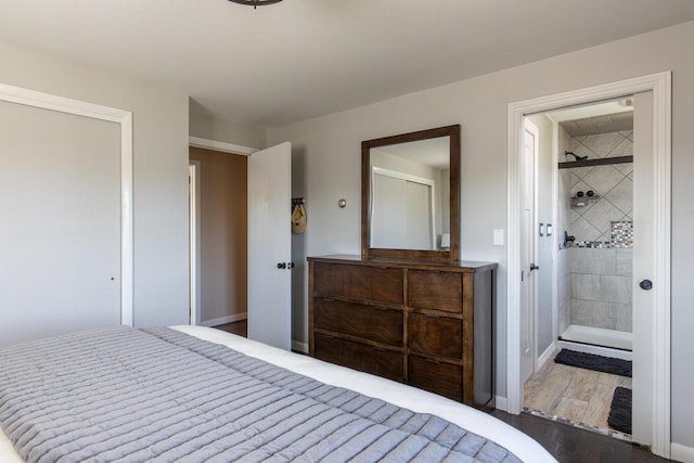 unfurnished bedroom with ensuite bath and dark wood-type flooring