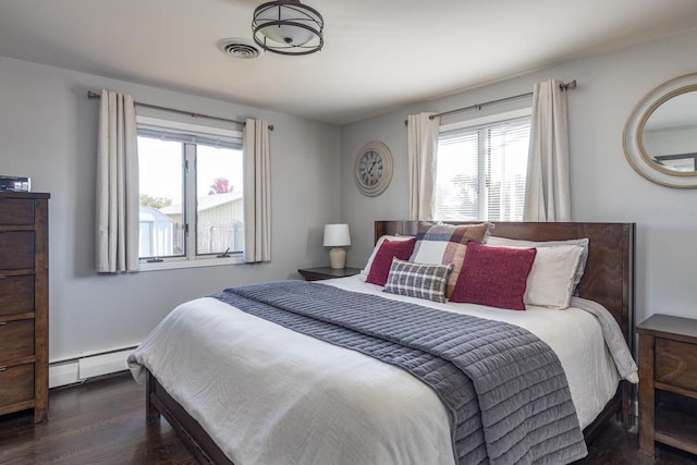 bedroom featuring baseboard heating and dark wood-type flooring