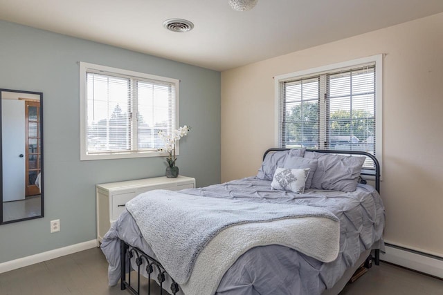 bedroom with multiple windows and baseboard heating