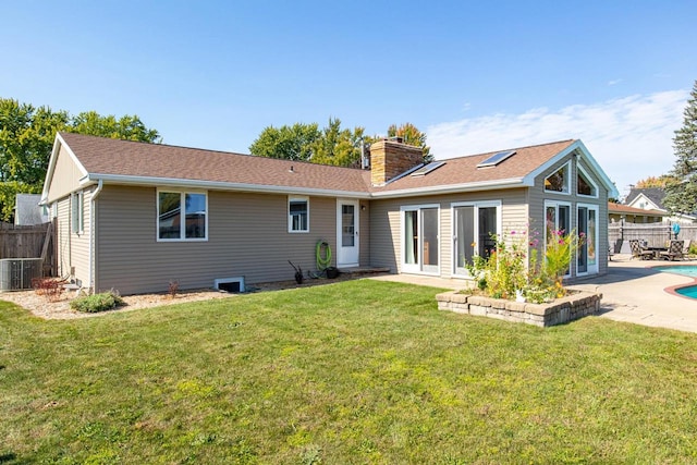 back of house with french doors, a fenced in pool, a lawn, and a patio area