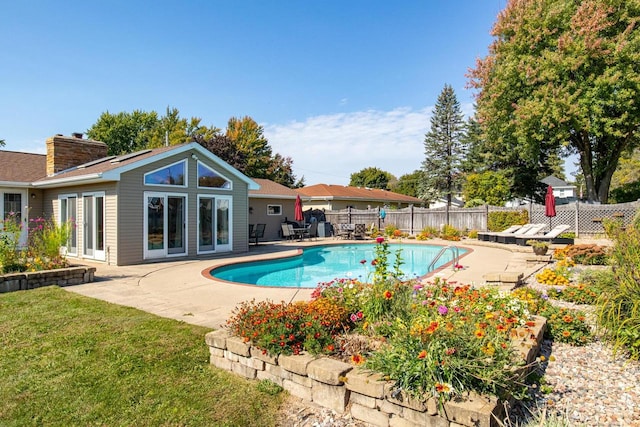 view of swimming pool with a patio and a yard