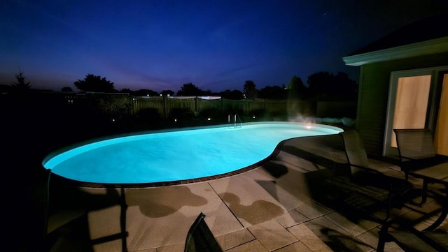 pool at dusk featuring a patio