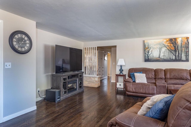 living room with a fireplace and dark wood-type flooring