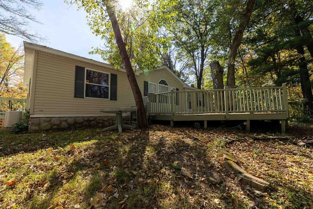 rear view of property with cooling unit and a deck