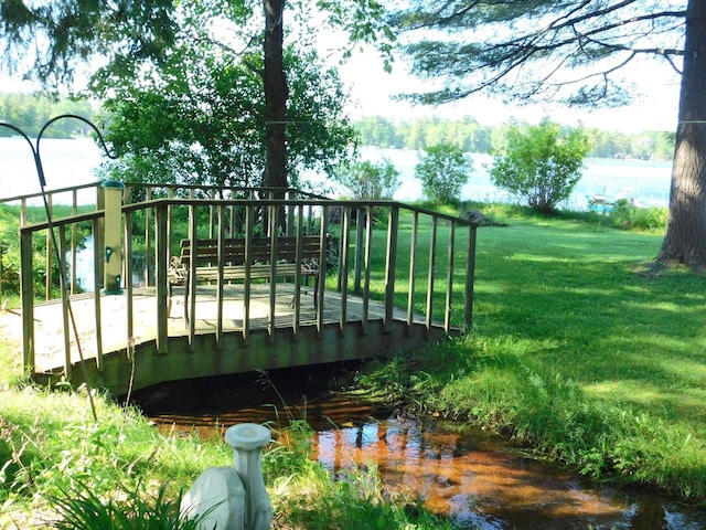 exterior space with a deck with water view and a yard