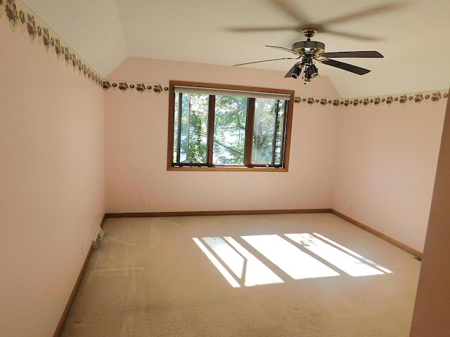 empty room with vaulted ceiling, light carpet, and ceiling fan