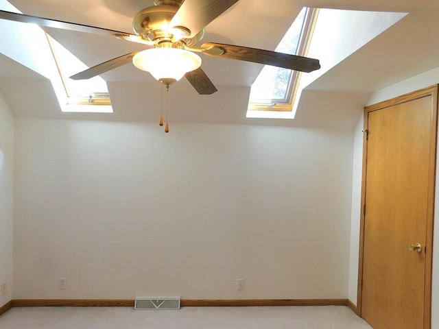 interior space with lofted ceiling with skylight and ceiling fan