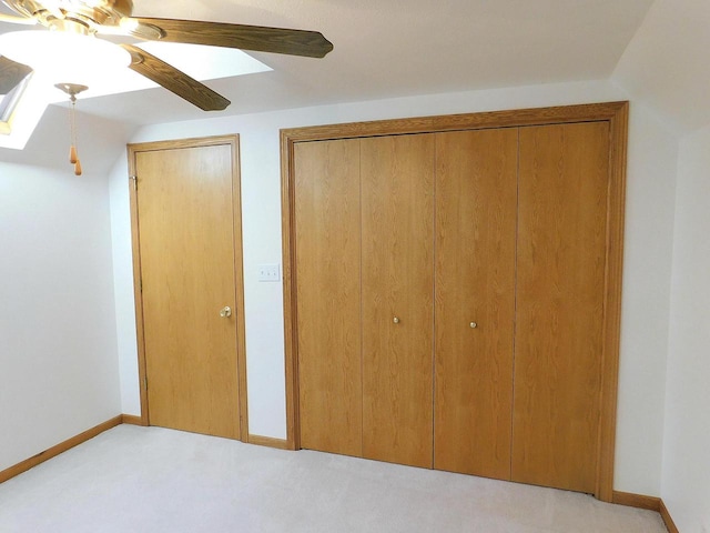 unfurnished bedroom with ceiling fan, vaulted ceiling, and light colored carpet