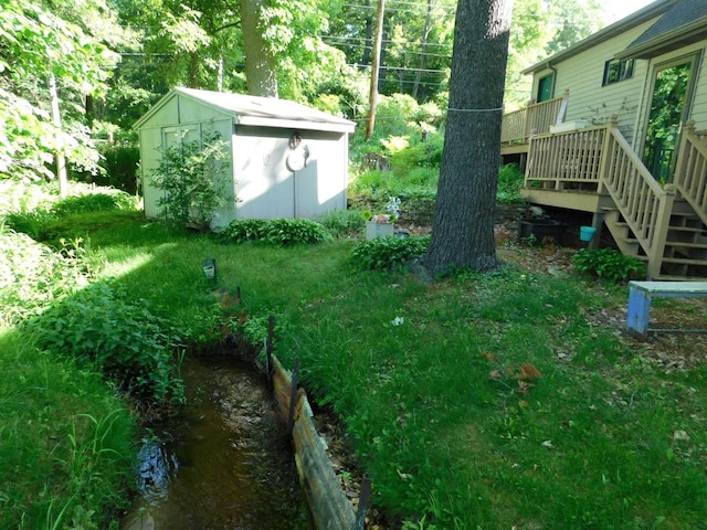 view of yard featuring a deck and a shed