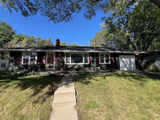 single story home featuring a front lawn and a garage