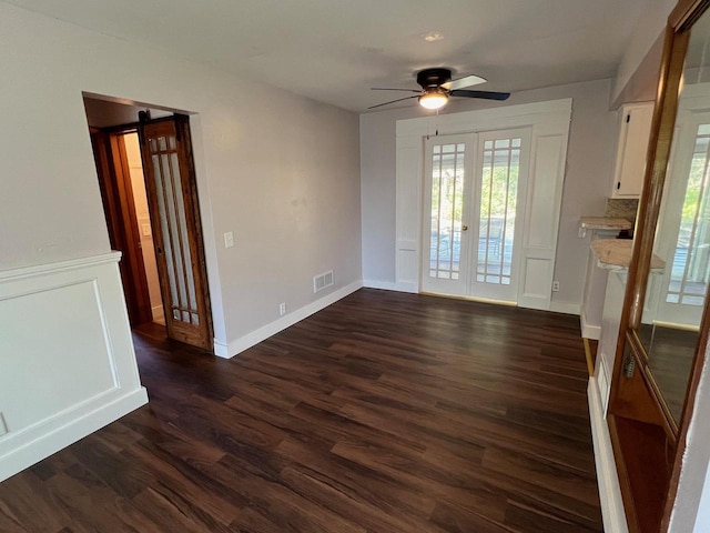 unfurnished dining area featuring french doors, ceiling fan, and dark wood-type flooring