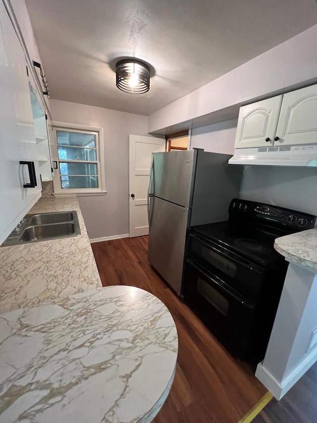 kitchen featuring range with two ovens, stainless steel fridge, sink, and white cabinets