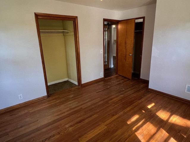 unfurnished bedroom with dark hardwood / wood-style floors and a closet