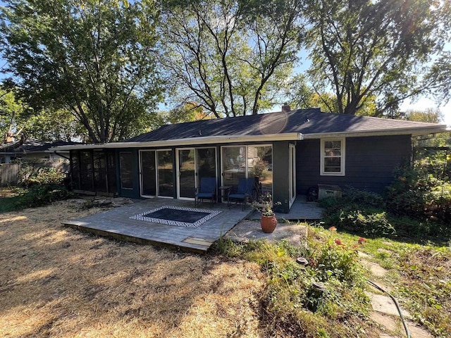 rear view of property with a deck and a sunroom