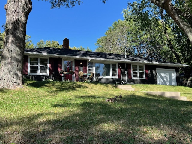 single story home featuring a garage and a front lawn