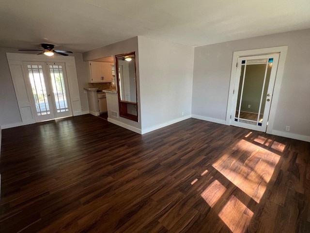 unfurnished living room featuring dark hardwood / wood-style floors, ceiling fan, and french doors