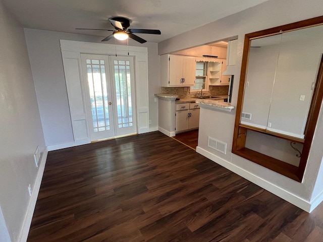 kitchen featuring sink, dark wood-type flooring, white cabinetry, backsplash, and french doors