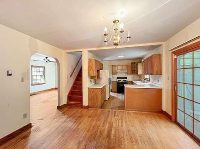 kitchen featuring light hardwood / wood-style floors, hanging light fixtures, a healthy amount of sunlight, and range