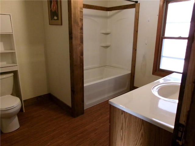 full bathroom with shower / bathing tub combination, vanity, hardwood / wood-style floors, and toilet