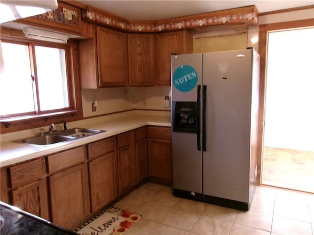 kitchen featuring stainless steel refrigerator with ice dispenser, sink, and light tile patterned flooring