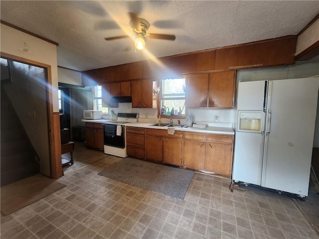 kitchen featuring ceiling fan, a textured ceiling, sink, and white appliances