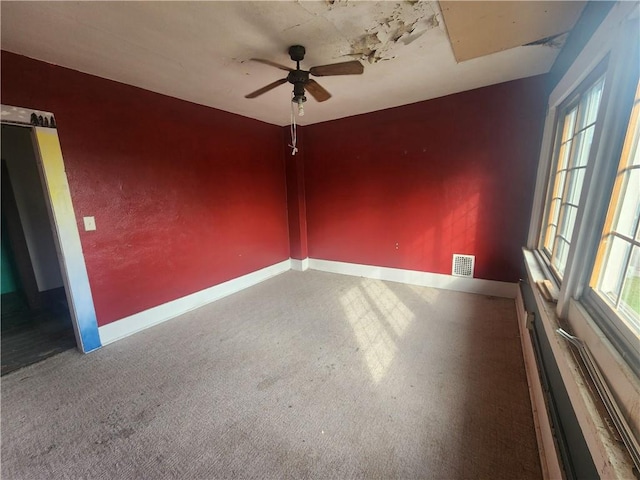 carpeted spare room featuring ceiling fan and a healthy amount of sunlight