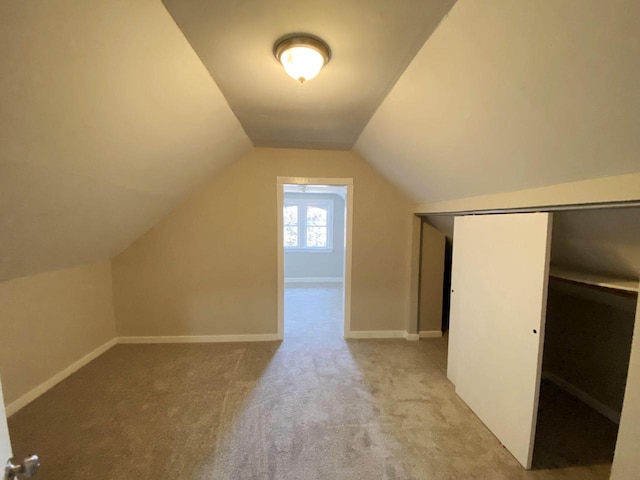 additional living space with vaulted ceiling and light colored carpet