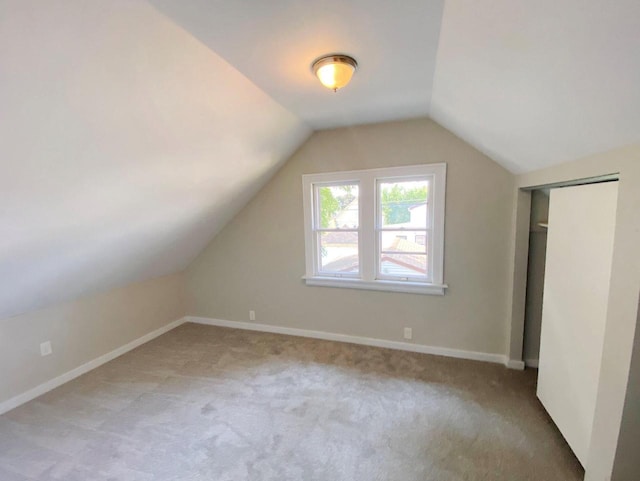 bonus room featuring vaulted ceiling and light colored carpet