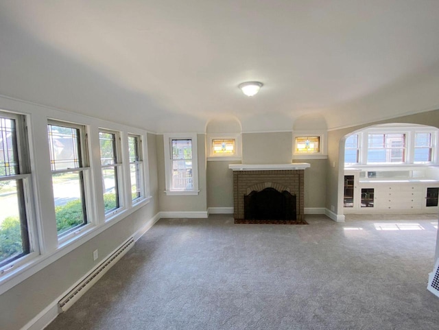 unfurnished living room featuring carpet floors, a fireplace, and a baseboard heating unit